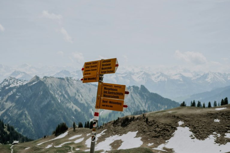 a group of signs on top of a snow covered mountain