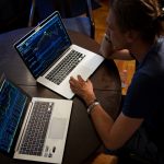 man sitting in front of the MacBook Pro