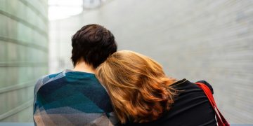 a woman rests her head on another person's shoulder