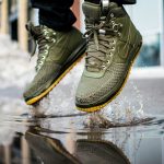 person wearing green Nike sneakers jumping on water